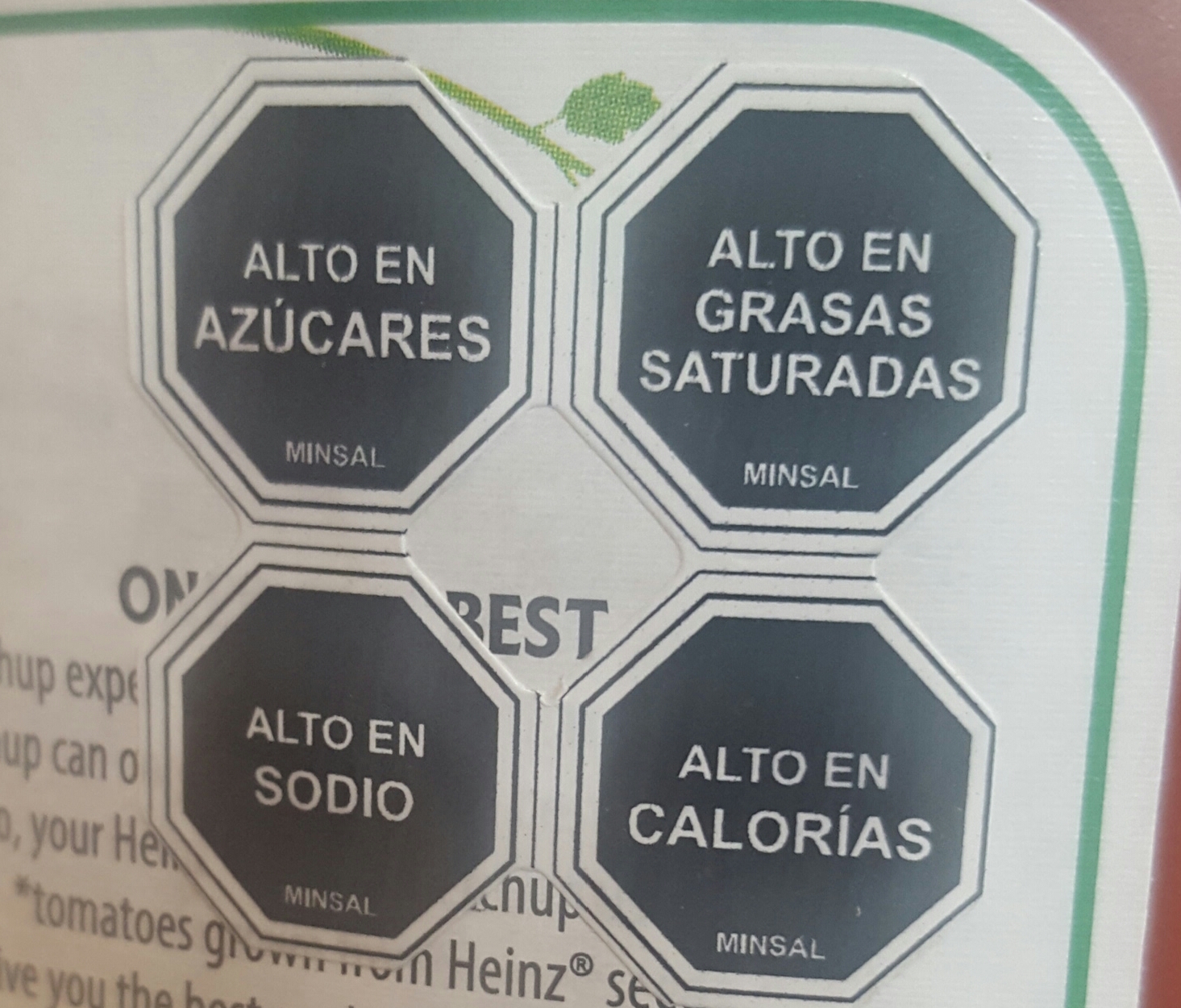 A Heinz ketchup bottle sold in Chile showing four black octagonal warning labels reading high in sugars, saturated fats, sodium, and calories